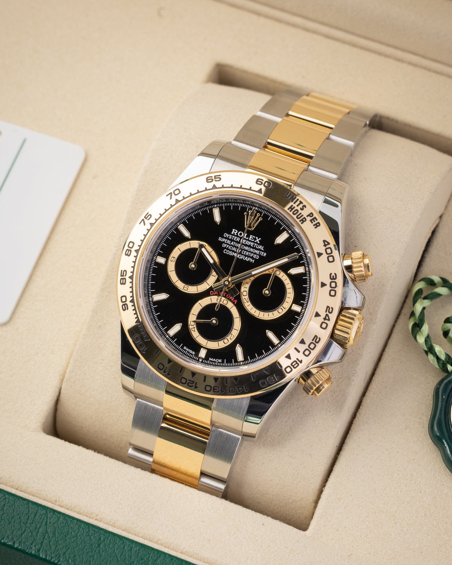 Angled view of preowned Rolex Cosmograph Daytona reference 126503 featuring an 18k yellow gold tachymeter bezel and black dial.