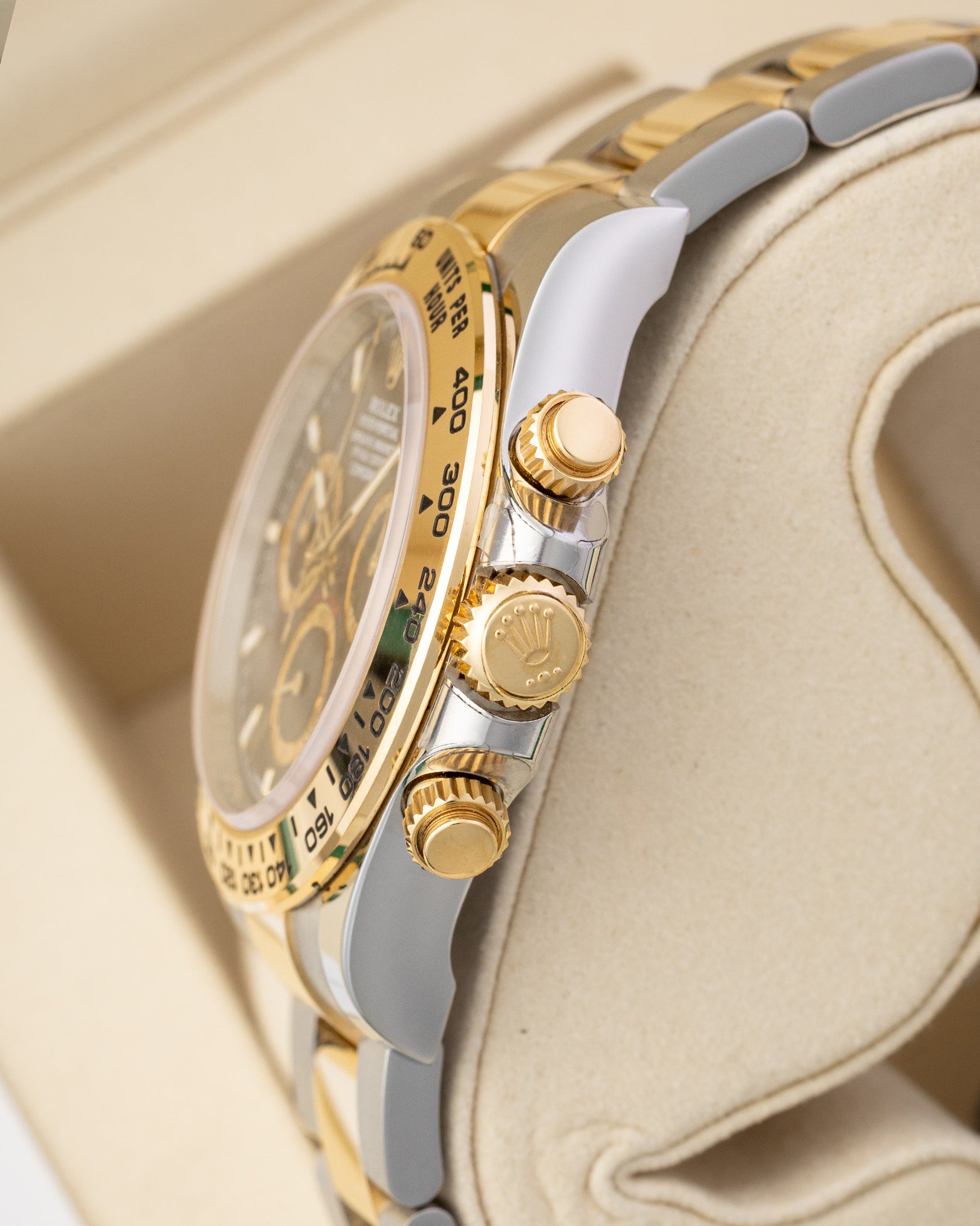 Side profile view showing 18k yellow gold crown, chronograph pushers, and Oystersteel case on Rolex Daytona 126503.