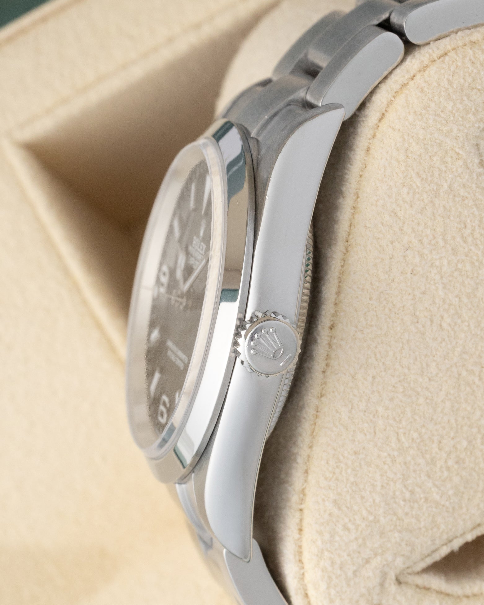 Side profile showing the stainless steel case and signed winding crown of a Rolex Explorer 114270