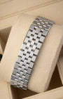 A rear view of the five-piece solid metal link watch band focusing on the secure closure of the low-profile folding Oysterclasp deployant buckle detailed with an embossed Rolex crown logo