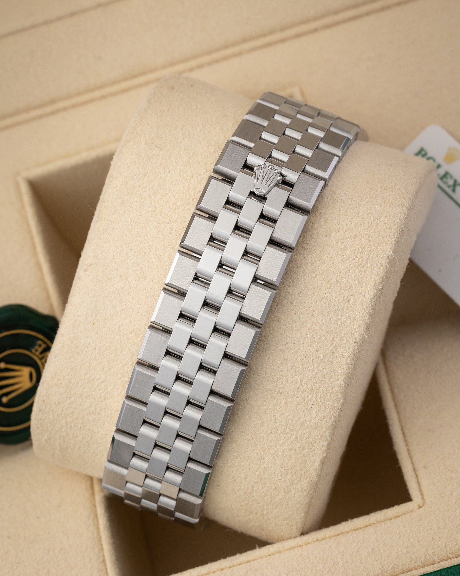 A rear view of the five-piece solid metal link watch band focusing on the secure closure of the low-profile folding Oysterclasp deployant buckle detailed with an embossed Rolex crown logo