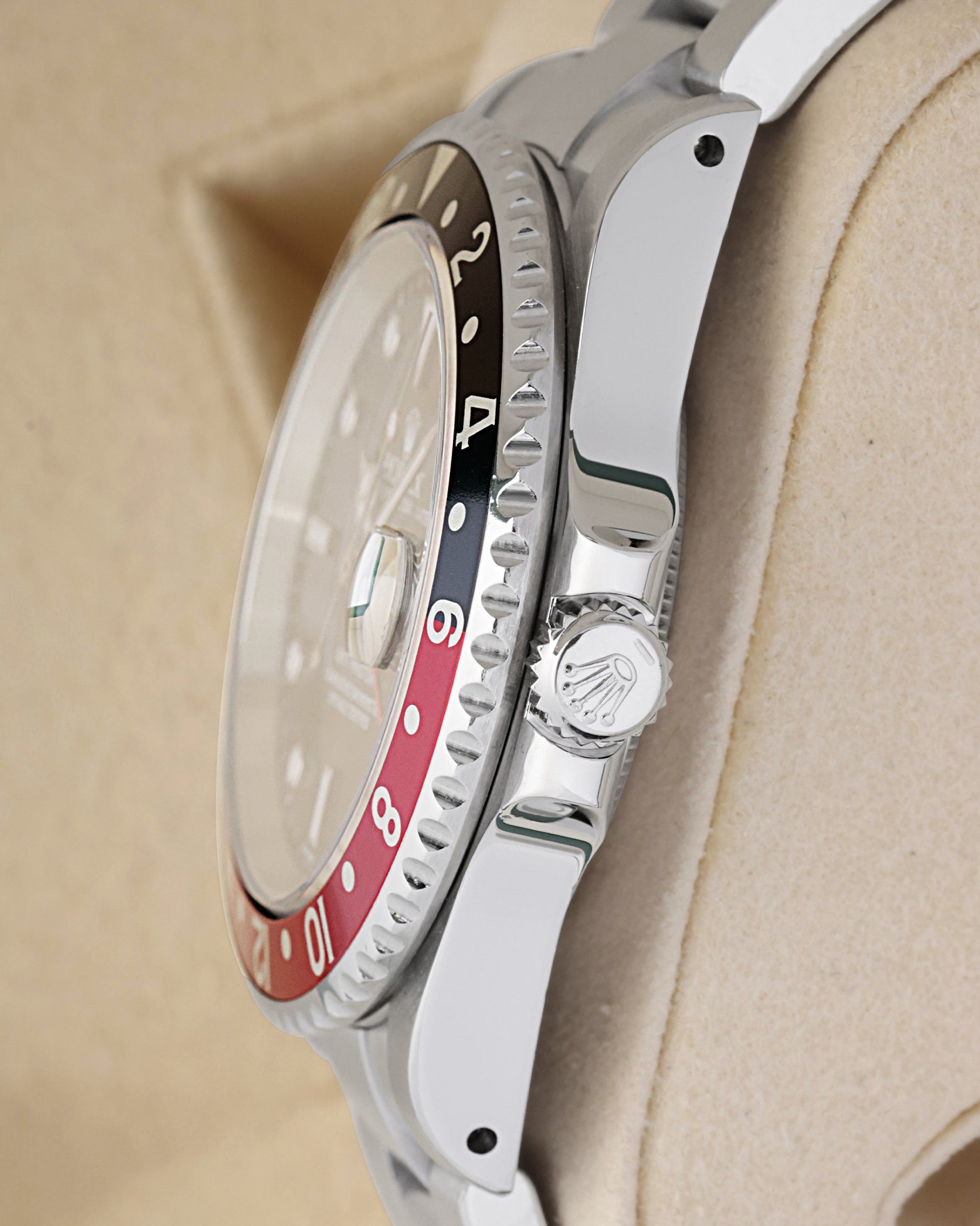 Side profile view of a stainless steel Rolex GMT-Master II case showing the crown guards, signed crown, and vintage style pierced lug holes