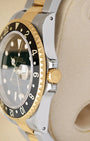 Side case profile focusing on the 18k yellow gold screw-down crown and protected guards of a 2004 two-tone Rolex GMT-Master II