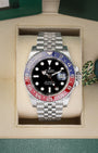 Front portrait view of a pre-owned 2022 Rolex GMT-Master II Ref 126710BLRO Pepsi watch resting in its original green presentation box, available at Noahs Fine Watches and Jewelry Dallas