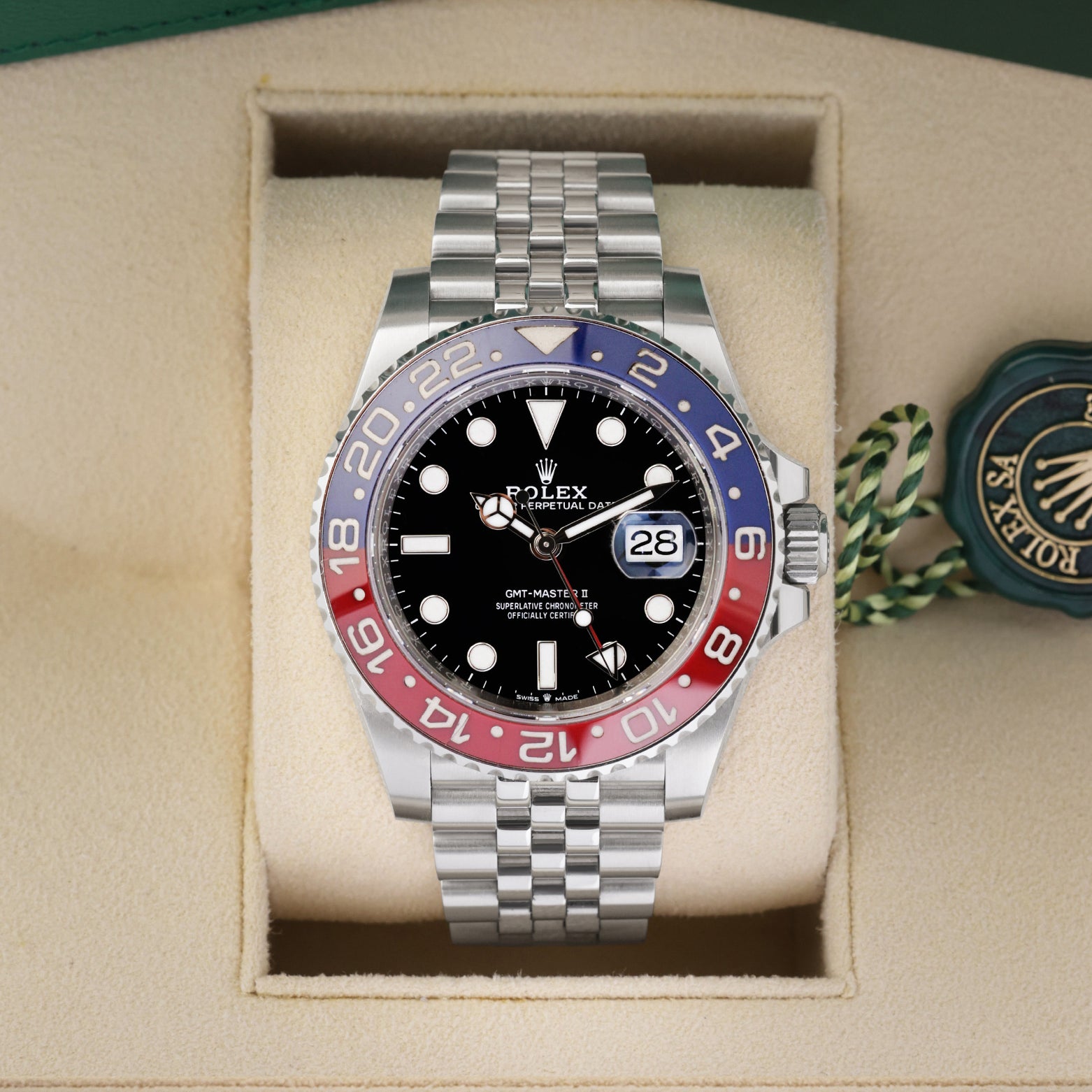 Front portrait view of a pre-owned 2022 Rolex GMT-Master II Ref 126710BLRO Pepsi watch resting in its original green presentation box, available at Noahs Fine Watches and Jewelry Dallas