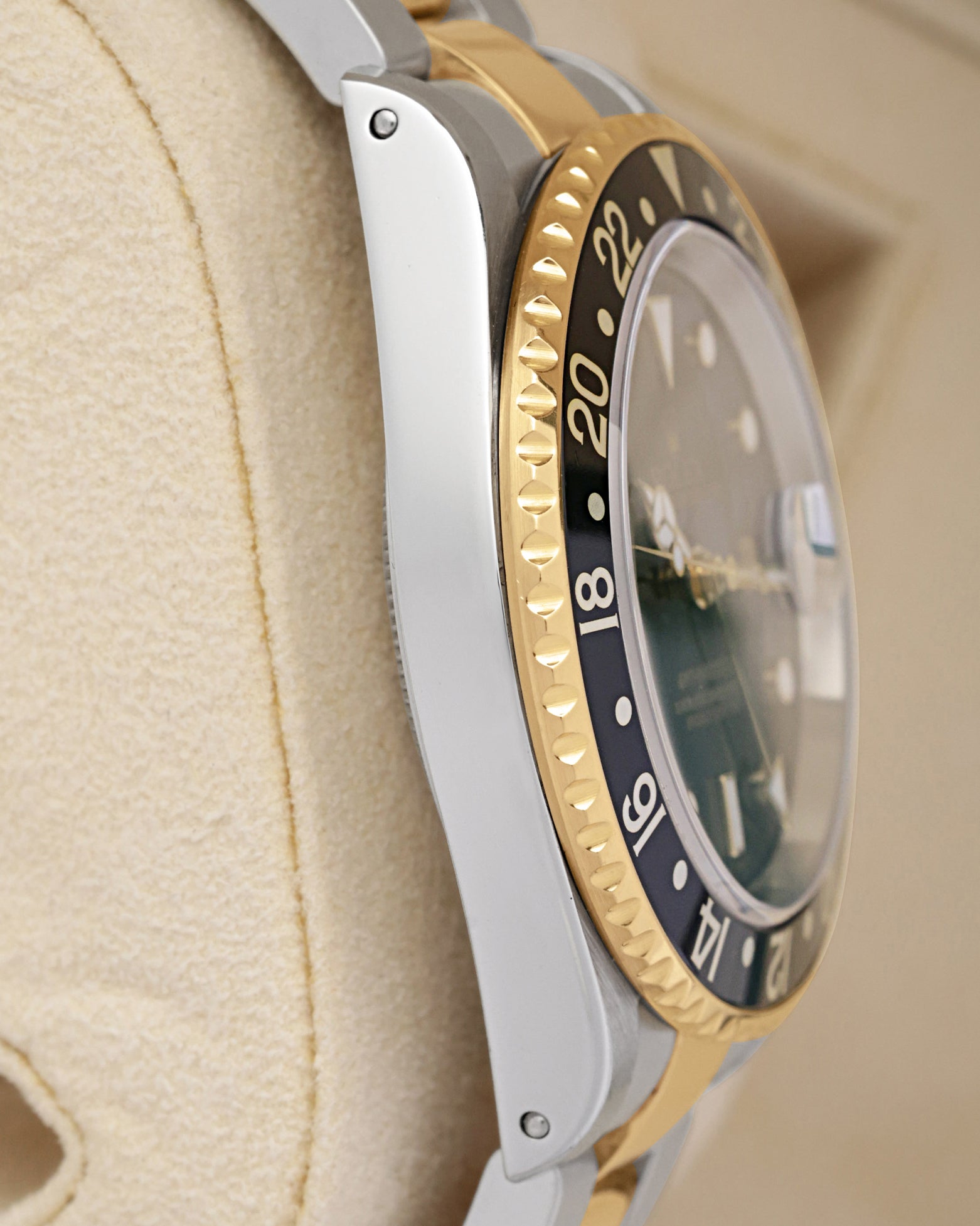 Left side perspective showcasing the high-polish finish on the stainless steel case side and the 18k yellow gold coin-edge bezel grip