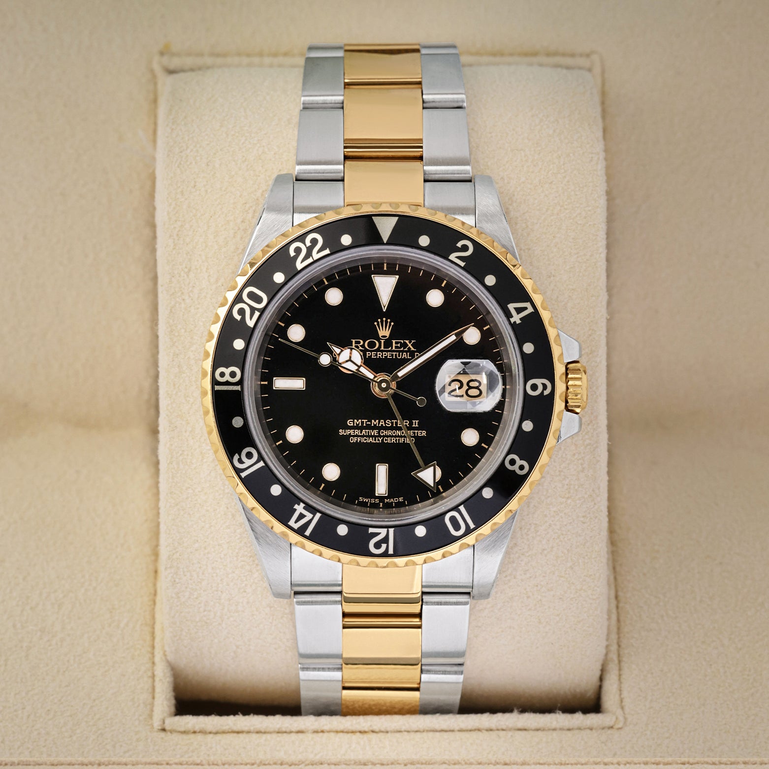 Front portrait view of a pre-owned 2004 Rolex GMT-Master II Ref 16713 two-tone yellow Rolesor watch with a black index dial, on display at Noahs Fine Watches and Jewelry Dallas
