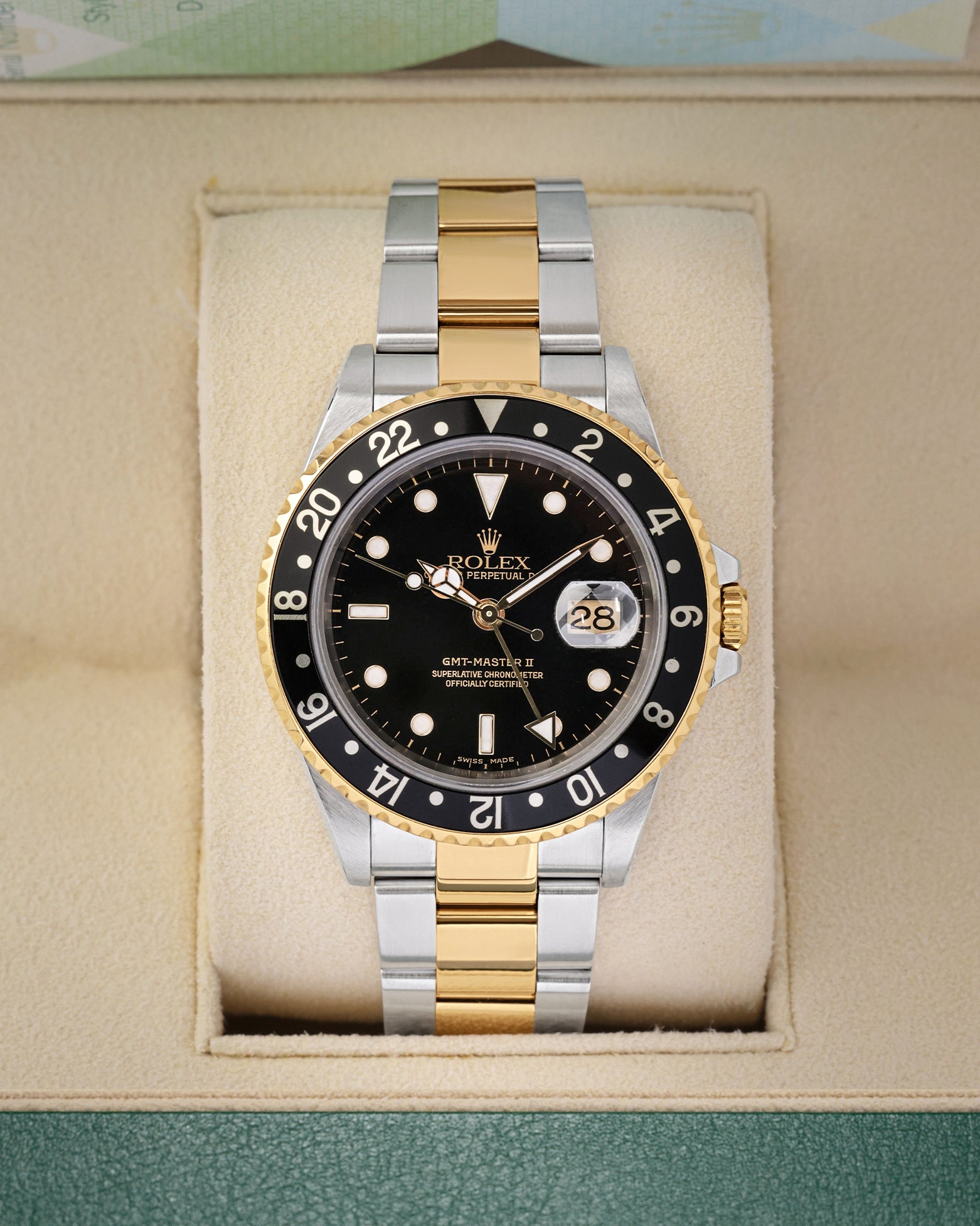 Front portrait view of a pre-owned 2004 Rolex GMT-Master II Ref 16713 two-tone yellow Rolesor watch with a black index dial, on display at Noahs Fine Watches and Jewelry Dallas