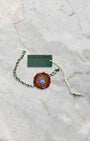 Official green holographic Rolex Superlative Chronometer string seal tag and white serialized pricing hang tag on marble