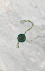 Official green and gold Rolex Superlative Chronometer certified hologram seal tag resting on a marble backdrop