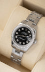 angled overhead view of the 26mm steel and white gold Rolex Lady-Datejust watch with a diamond bezel resting on a beige leather watch cushion