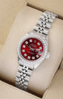 An angled studio view of a stainless steel 26mm Rolex Lady-Datejust watch resting on a cream display cushion