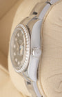 Close-up right profile view of the slim watch head focusing on the factory-set diamond bezel edge, sapphire Cyclops lens, and fluted steel Twinlock winding crown