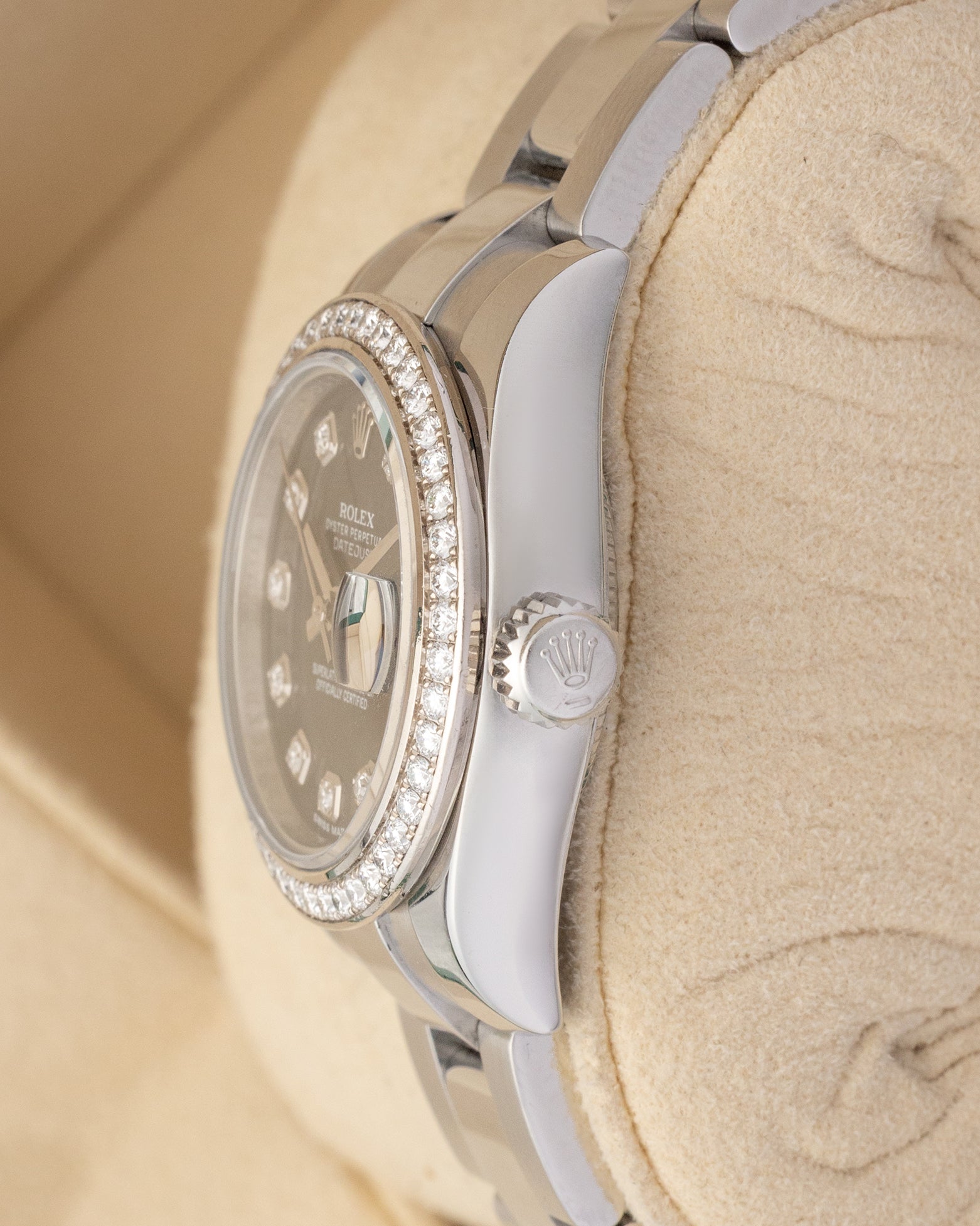 Close-up right profile view of the slim watch head focusing on the factory-set diamond bezel edge, sapphire Cyclops lens, and fluted steel Twinlock winding crown