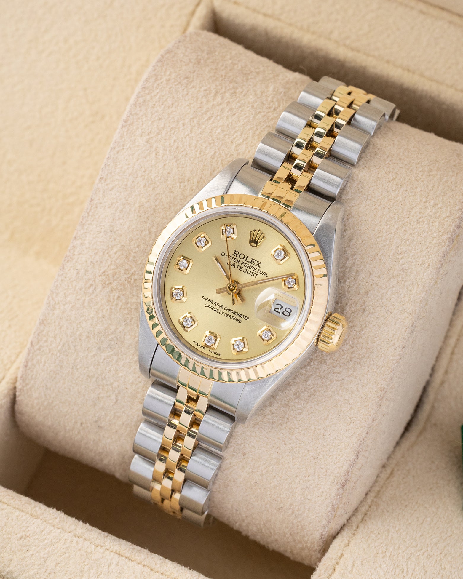 angled profile view of a vintage two-tone Rolex Lady-Datejust 69173 showcasing factory diamond hour markers and a gold fluted bezel