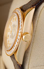 Side profile view of the 1984 vintage Rolex Lady-Datejust 69178 18k yellow gold case, diamond bezel edge, and gold winding crown.