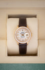 1984 vintage Rolex Lady-Datejust 69178 in 18k yellow gold featuring a mother of pearl diamond dial, diamond bezel, and dark brown leather strap inside presentation box.