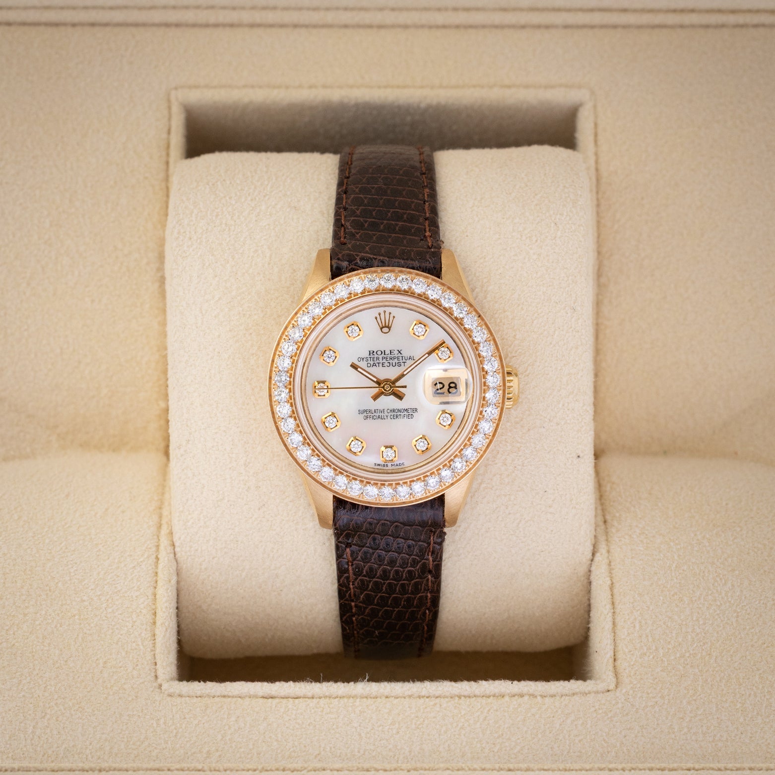 1984 vintage Rolex Lady-Datejust 69178 in 18k yellow gold featuring a mother of pearl diamond dial, diamond bezel, and dark brown leather strap inside presentation box.