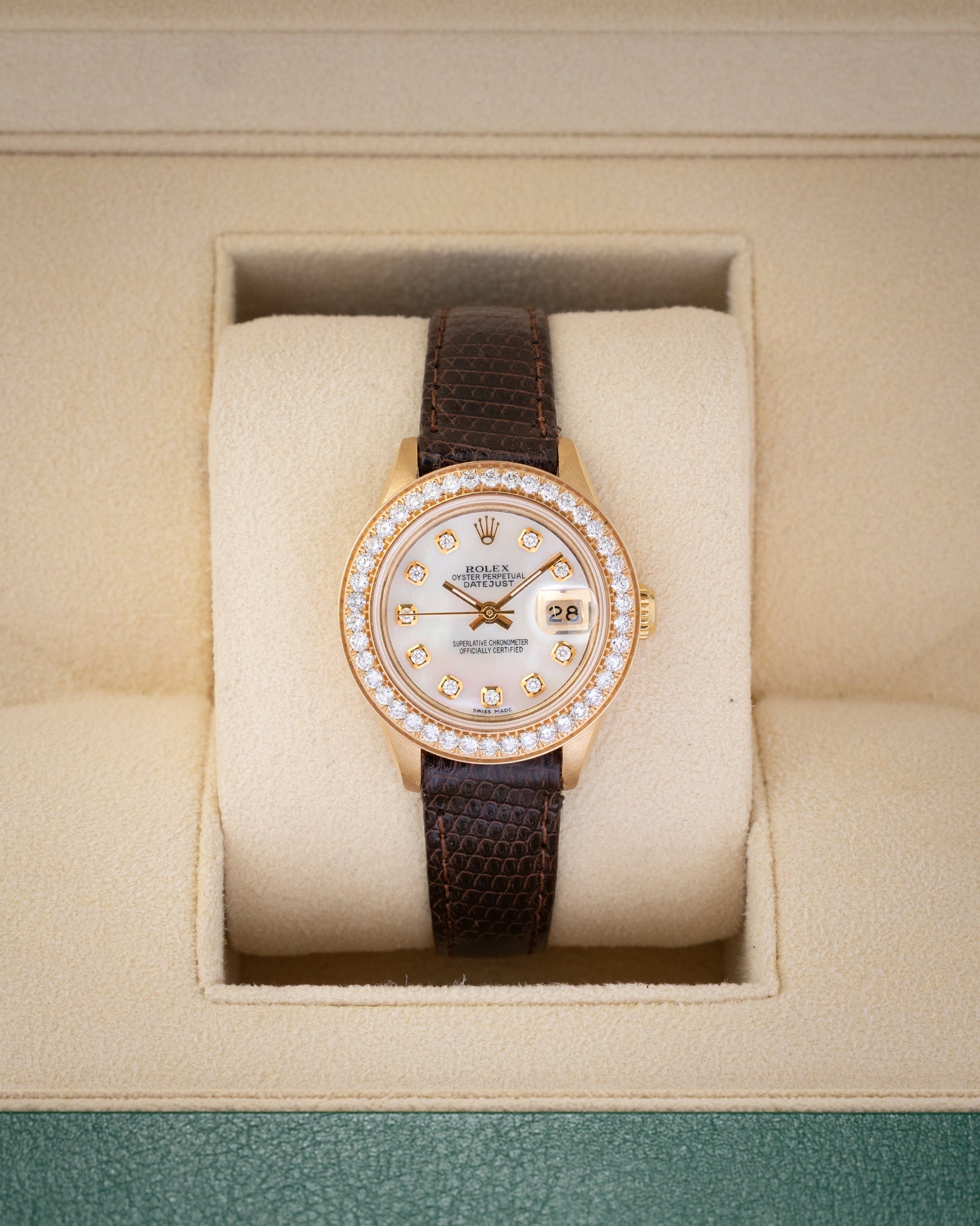 1984 vintage Rolex Lady-Datejust 69178 in 18k yellow gold featuring a mother of pearl diamond dial, diamond bezel, and dark brown leather strap inside presentation box.
