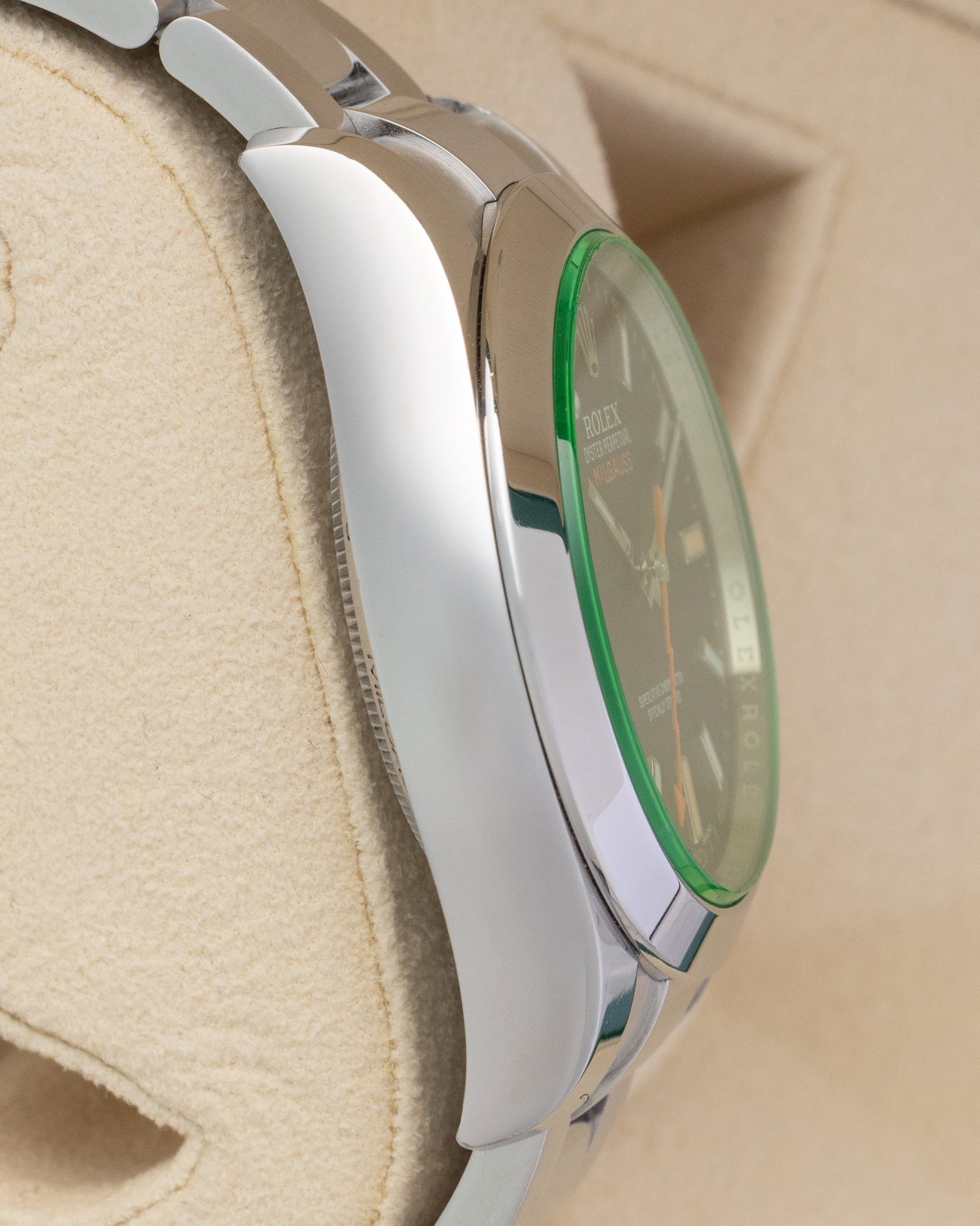 Left side profile view highlighting the polished Oystersteel case flank and green sapphire crystal profile on a 2019 Rolex Milgauss reference 116400GV