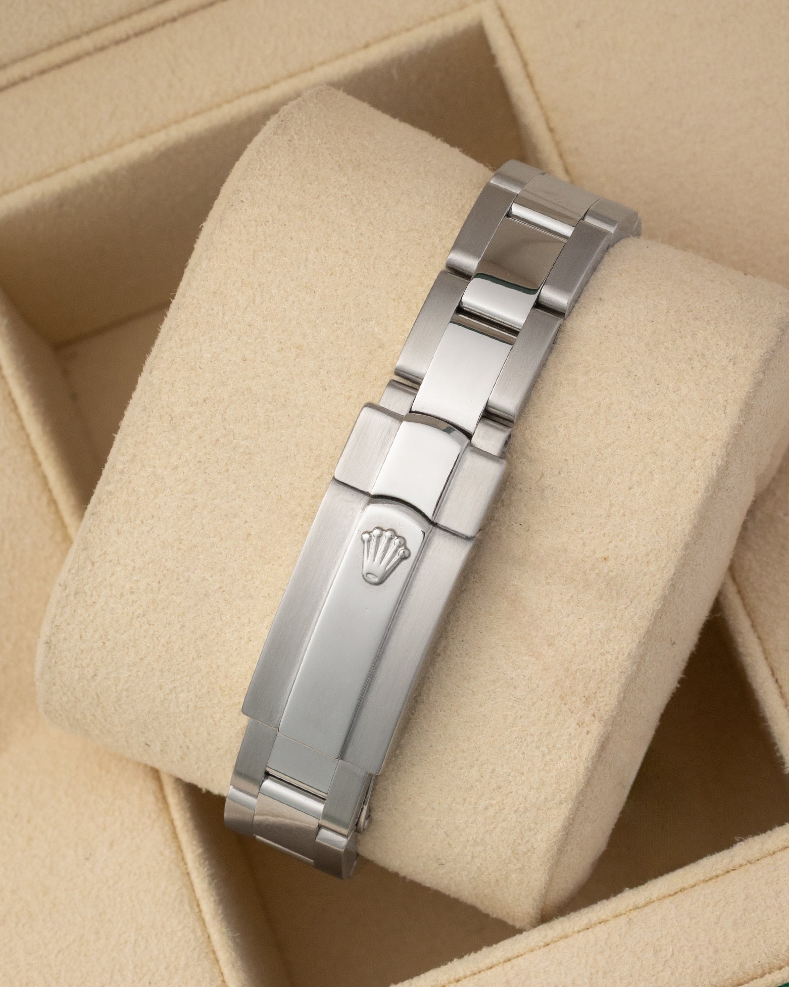 A rear view of the three-piece metal link watch band focusing on the secure closure of the folding Oysterclasp detailed with an embossed Rolex crown logo