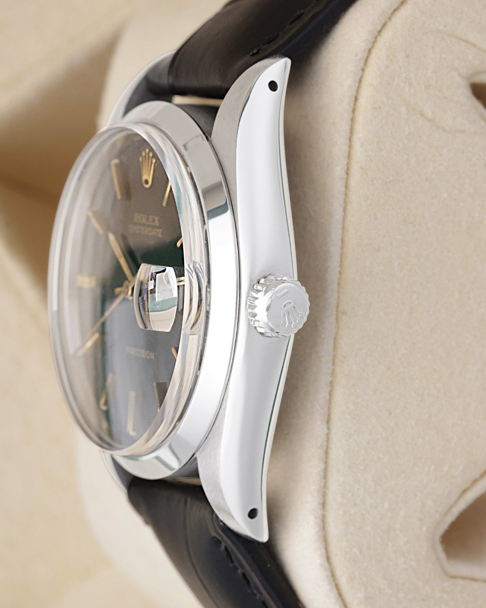 Side profile view of a stainless steel vintage Rolex 6694 showing the smooth bezel, acrylic crystal, and signed screw-down Oyster crown
