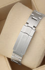 A rear view of the three-piece metal watch band focusing on the secure, flush interface of the folding Oysterclasp deployant buckle detailed with the signature debossed Rolex crown