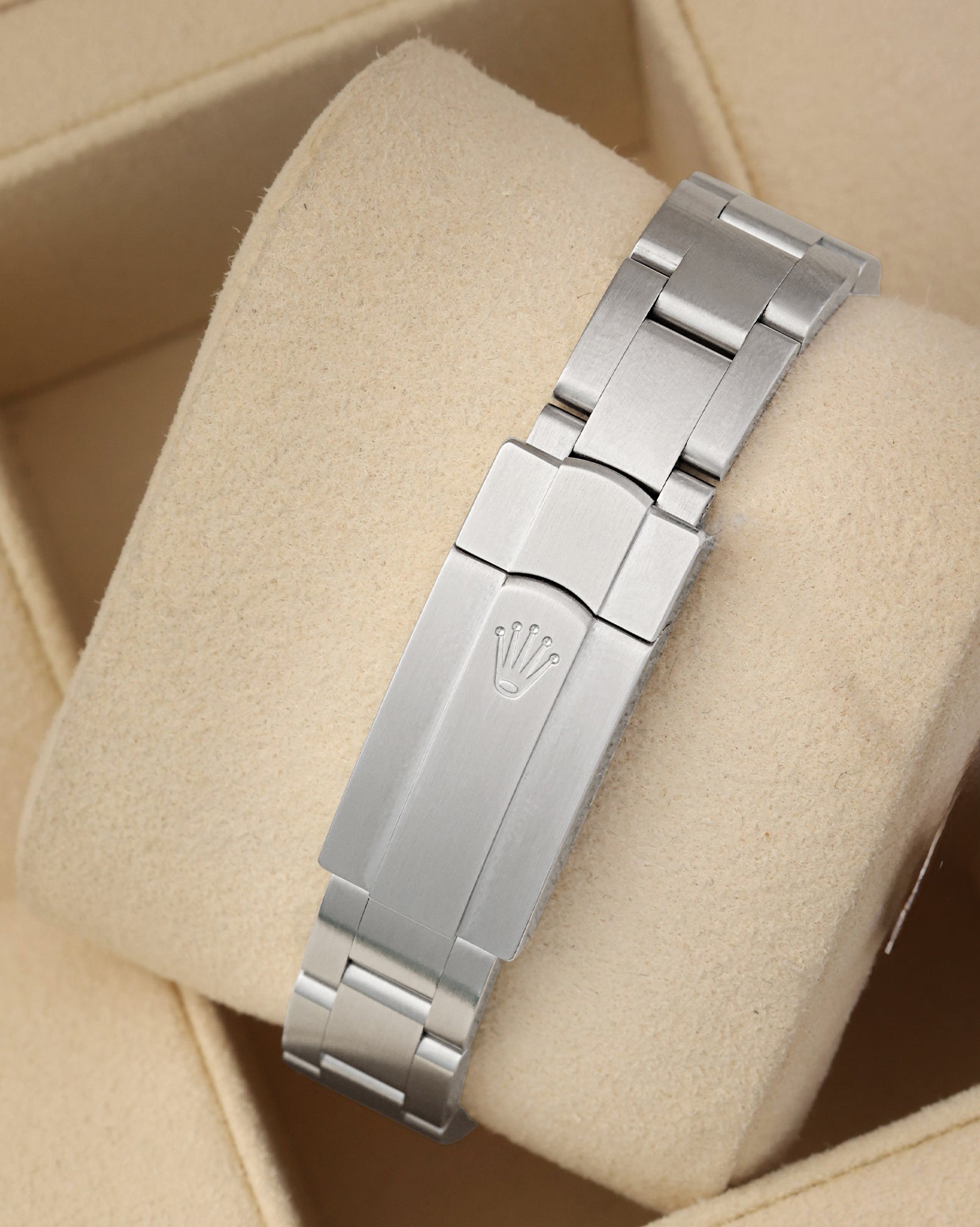 A rear view of the three-piece metal watch band focusing on the secure, flush interface of the folding Oysterclasp deployant buckle detailed with the signature debossed Rolex crown