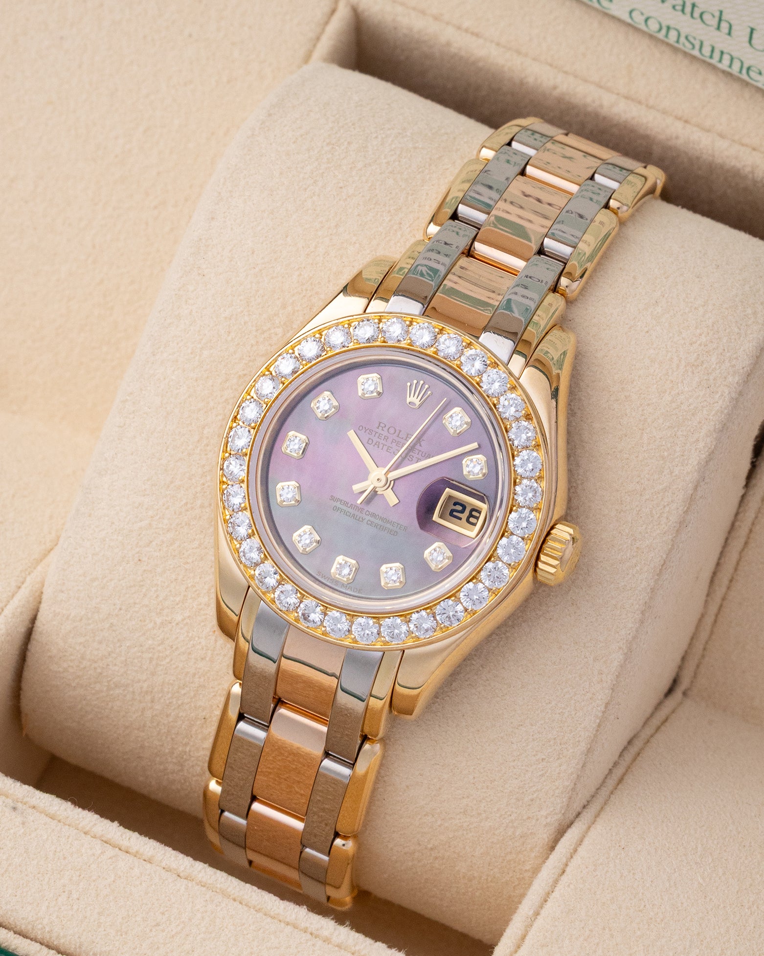 Angled view of Rolex Pearlmaster 80298 featuring factory diamond bezel, black MOP dial, and tri-tone gold Pearlmaster bracelet
