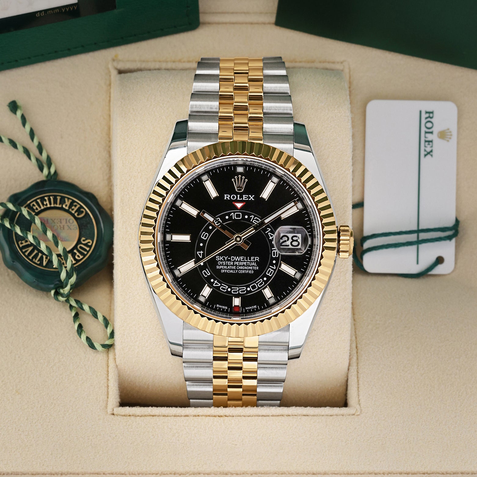 Front view of a pre-owned 2021 Rolex Sky-Dweller Ref 326933 yellow Rolesor two-tone watch with a bright black index dial and Jubilee bracelet, on display at Noahs Fine Watches and Jewelry Dallas