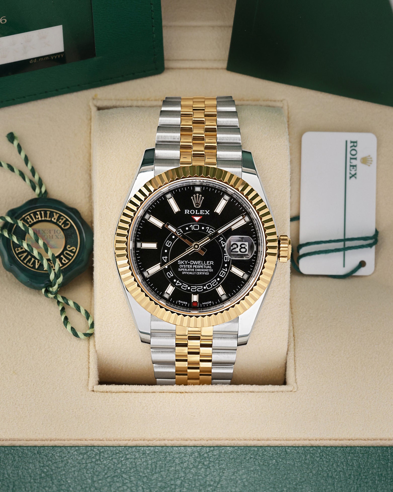 Front view of a pre-owned 2021 Rolex Sky-Dweller Ref 326933 yellow Rolesor two-tone watch with a bright black index dial and Jubilee bracelet, on display at Noahs Fine Watches and Jewelry Dallas