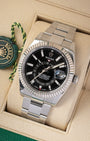 e-commerce portrait of the 42mm Sky-Dweller showcasing the Saros annual calendar red month indicator windows and solid Oyster bracelet on a beige display cushion