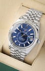 angled profile view of a pre-owned Rolex Sky-Dweller reference 326934 showcasing the bright blue annual calendar dial and steel Jubilee bracelet