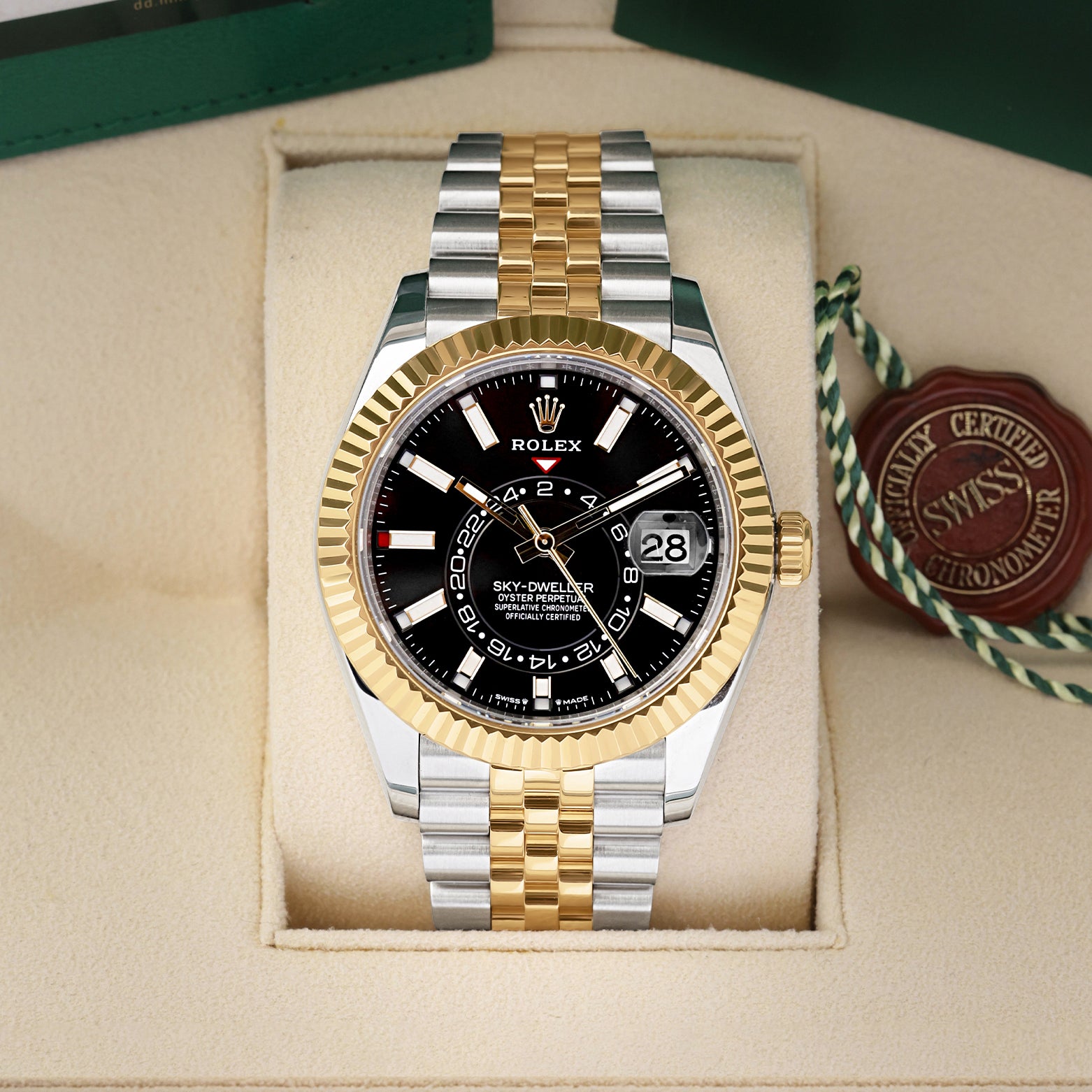 Front view of a pre-owned 2023 Rolex Sky-Dweller Ref 336933 yellow Rolesor two-tone watch with a bright black index dial and Jubilee bracelet, on display at Noahs Fine Watches and Jewelry Dallas