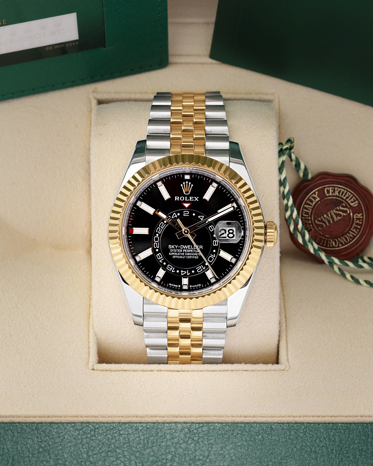 Front view of a pre-owned 2023 Rolex Sky-Dweller Ref 336933 yellow Rolesor two-tone watch with a bright black index dial and Jubilee bracelet, on display at Noahs Fine Watches and Jewelry Dallas
