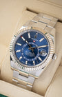angled top-down overview of the 42mm White Rolesor Rolex Sky-Dweller watch with a blue dial resting on its tan leather cushion