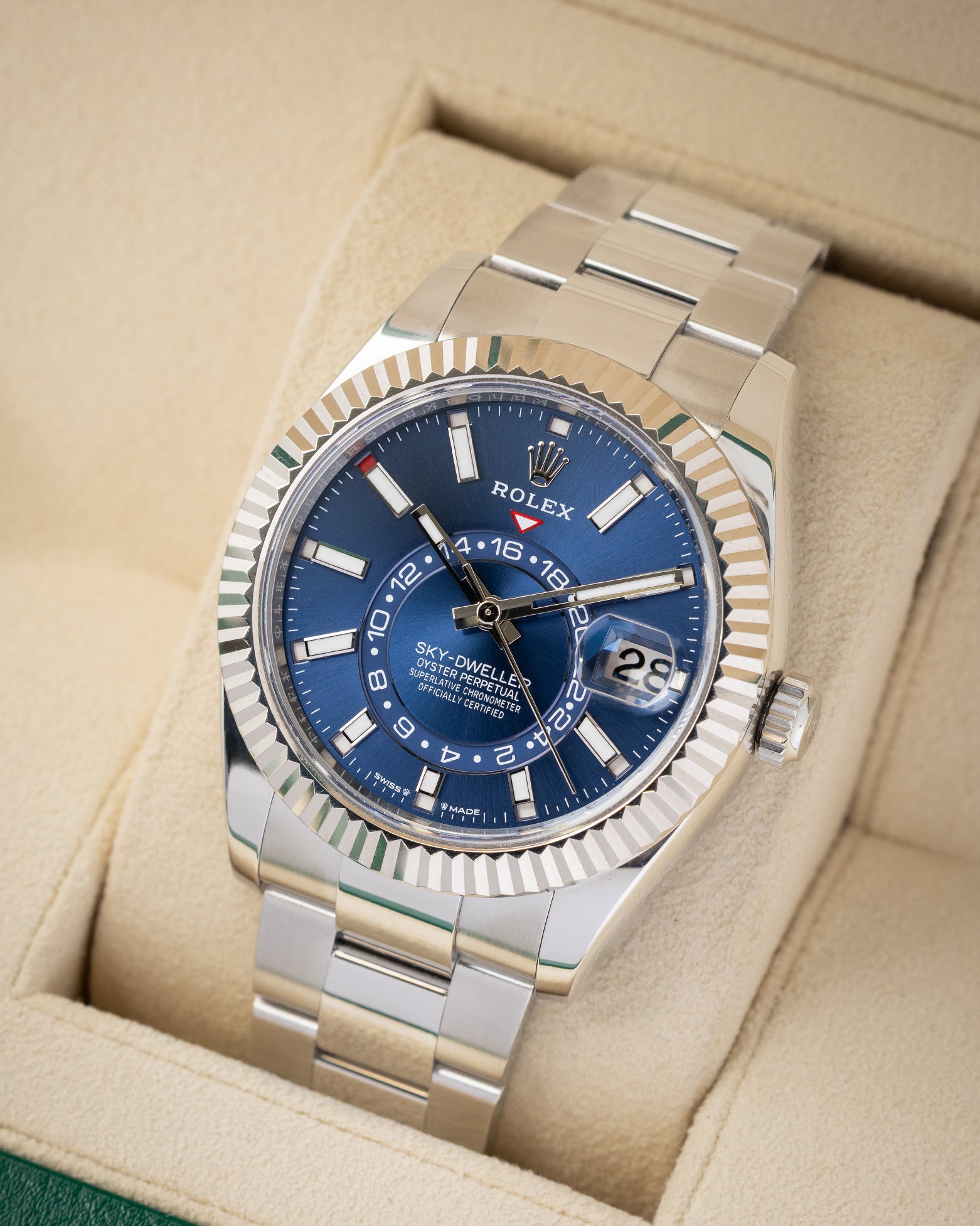 angled top-down overview of the 42mm White Rolesor Rolex Sky-Dweller watch with a blue dial resting on its tan leather cushion