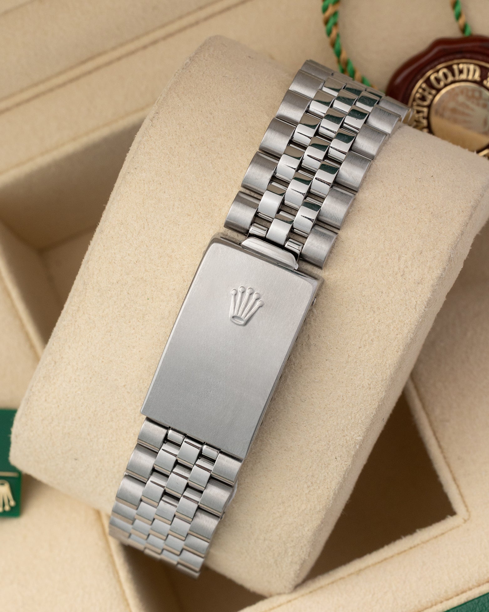 A rear view of the stainless steel Jubilee metal link watch band focusing on the secure closure of the classic stamped fold-over deployant clasp detailed with the Rolex crown emblem
