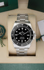 Front portrait of a pre-owned 2025 Rolex Submariner No-Date ref 124060 in its presentation box, available at Noahs Fine Watches and Jewelry Dallas