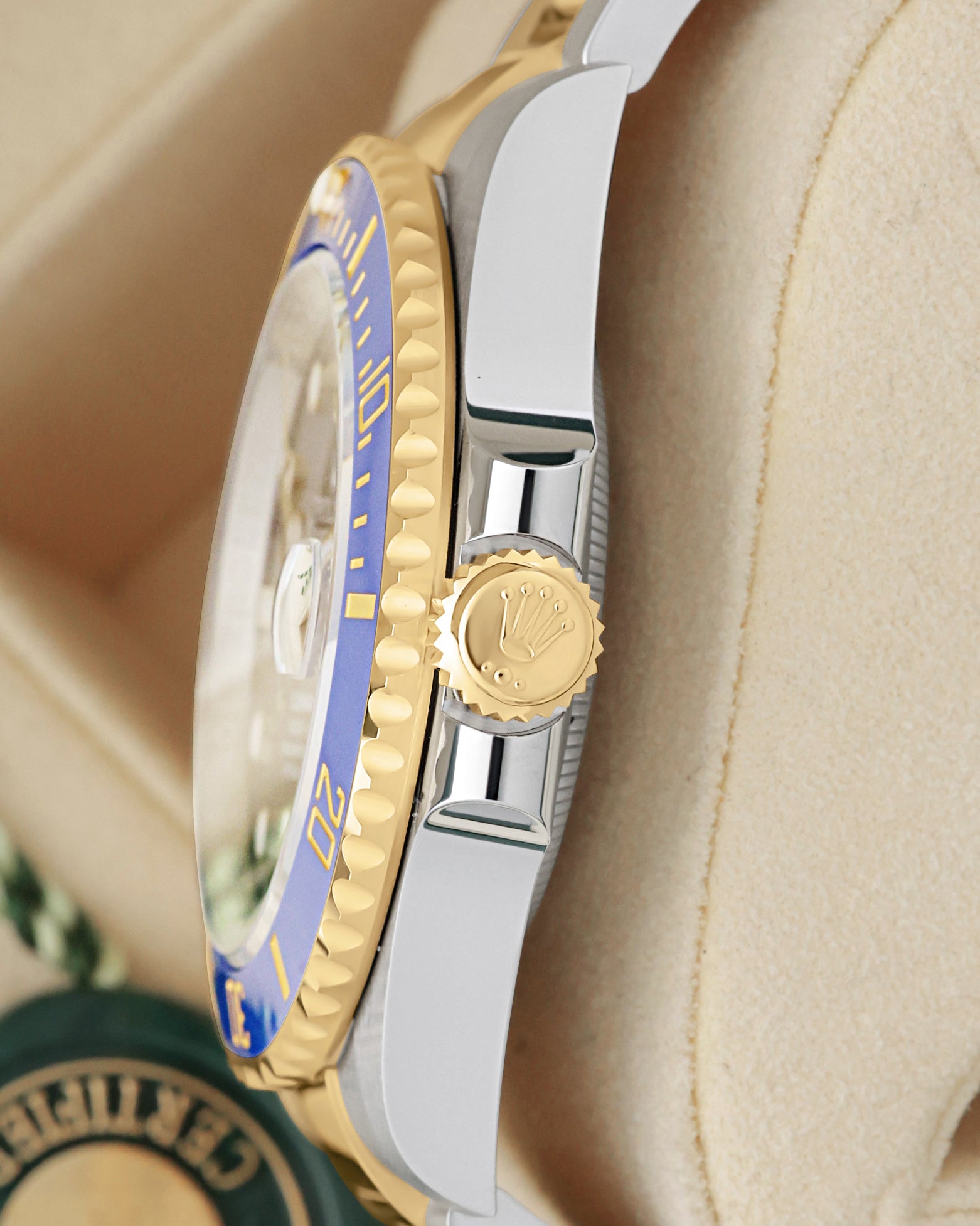Side view close-up of the 18k yellow gold Triplock screw-down crown and blue Cerachrom bezel on Rolex Submariner 126613LB