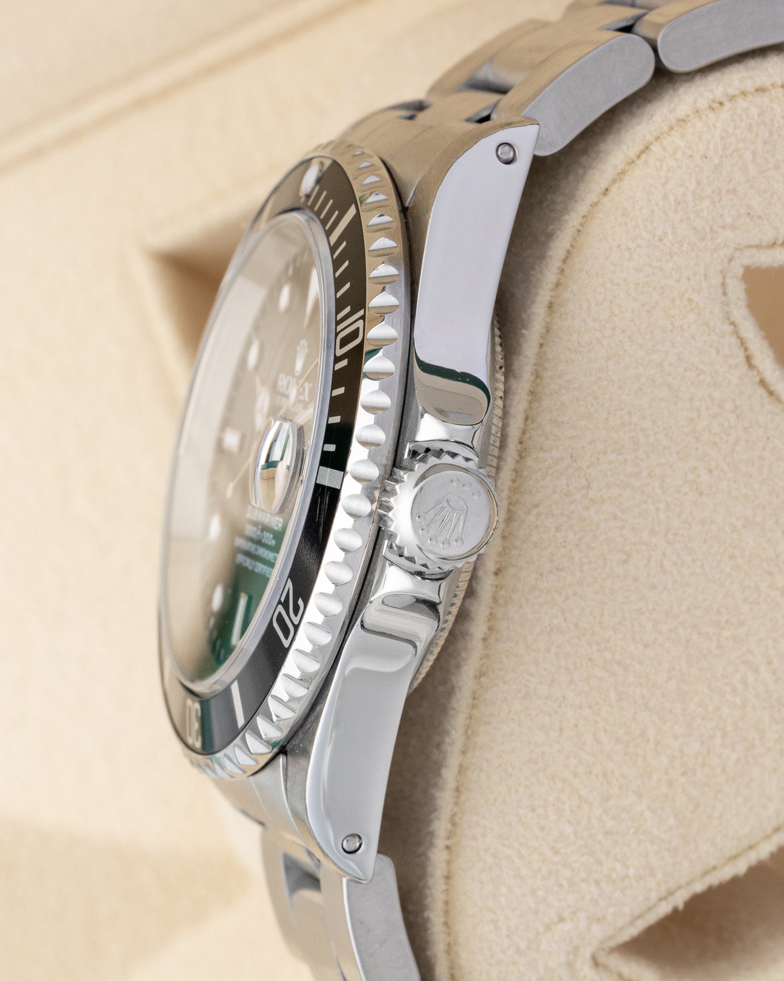 Side profile showing the 40mm stainless steel case, crown guards, and signed Triplock winding crown on a Rolex Submariner Date 16610