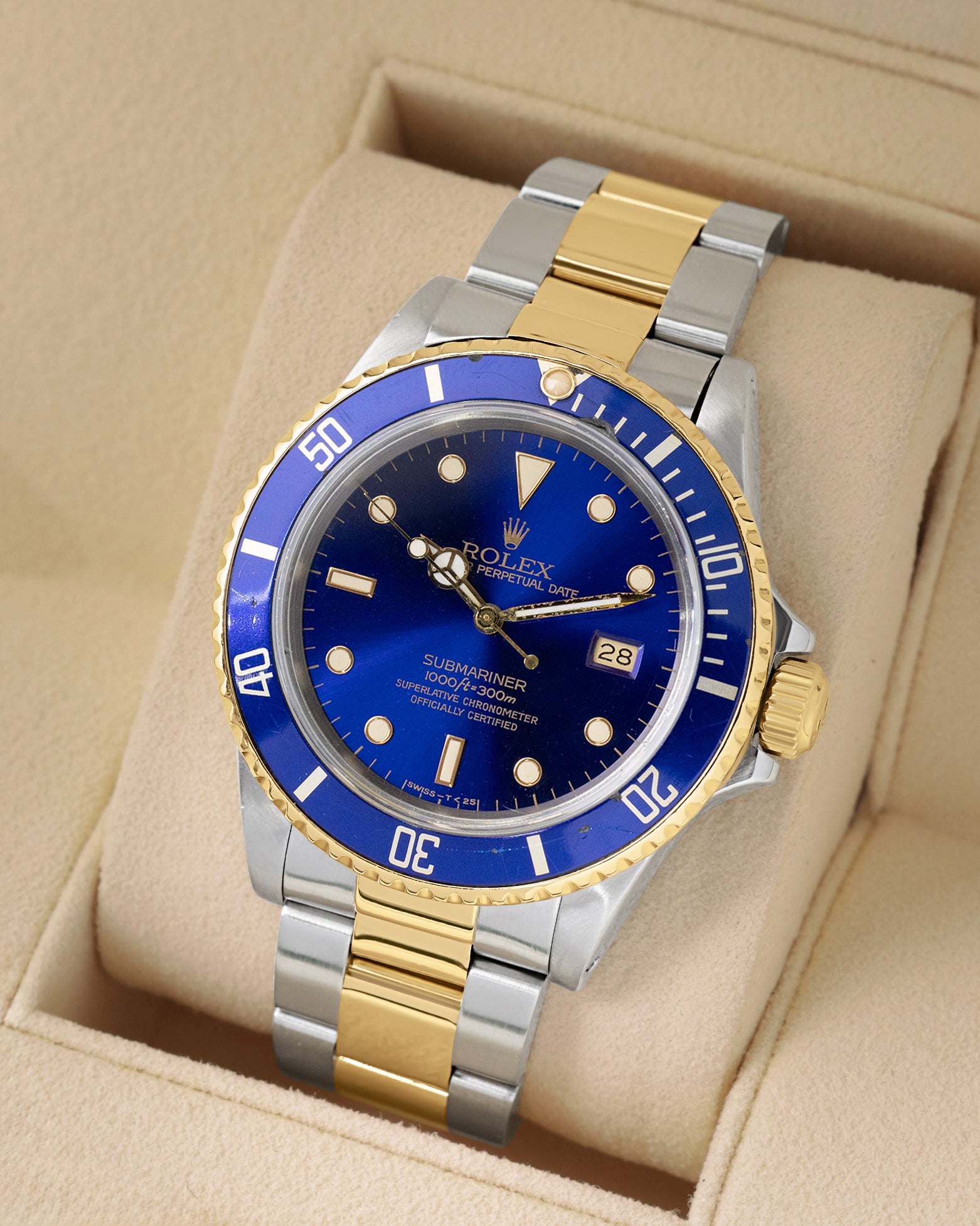 angled view of vintage 1986 Rolex Submariner 16803 featuring a blue dial, gold bezel insert, and two-tone Oyster bracelet