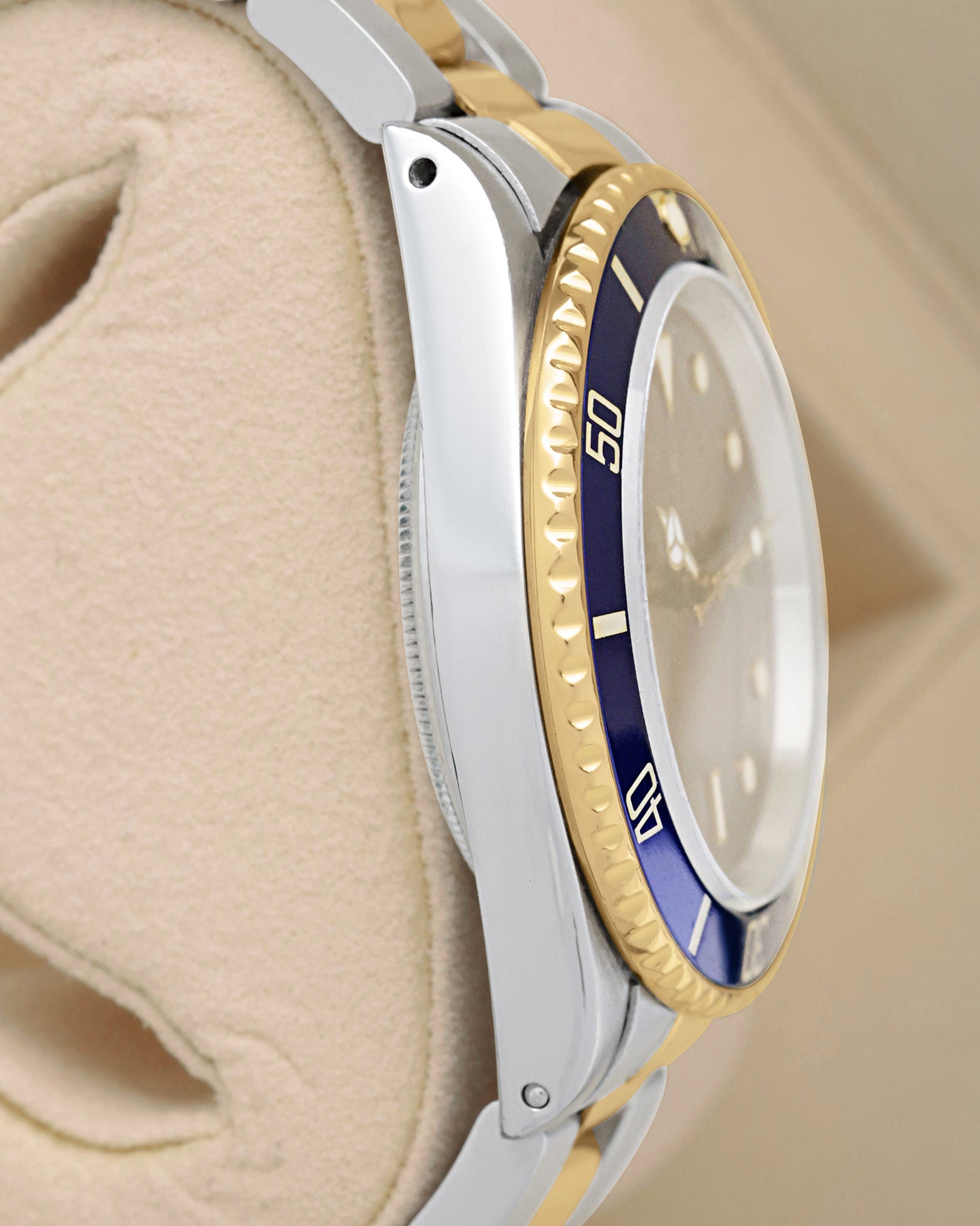 Side profile view showing the holes case design of the vintage 1986 Rolex Submariner 16803 in stainless steel and 18k gold