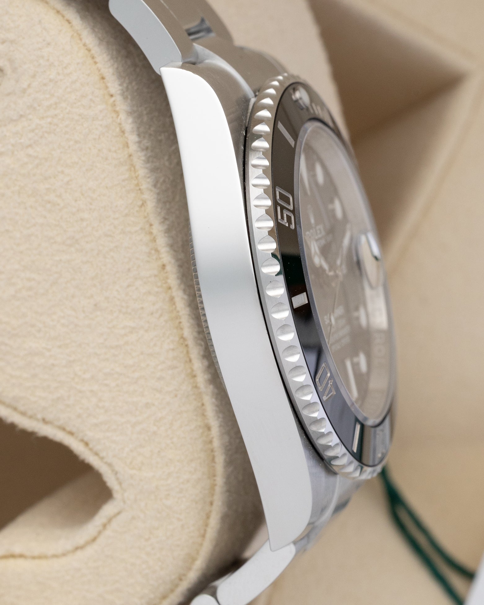 Left side profile view highlighting the polished steel case wall on a preowned 2025 Rolex Submariner Date reference 126610LN