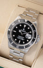 Angled front view of a vintage 1999 Rolex Submariner Date 16610 featuring a black dial, cyclops lens date display, and black aluminum bezel insert