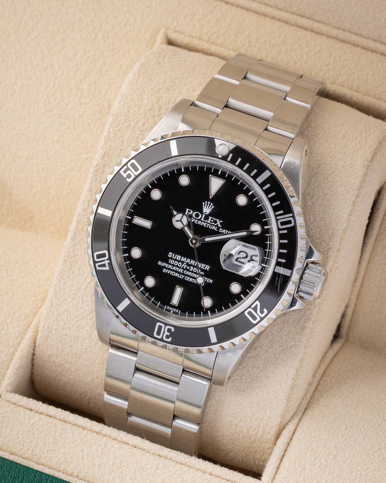 Angled front view of a vintage 1999 Rolex Submariner Date 16610 featuring a black dial, cyclops lens date display, and black aluminum bezel insert