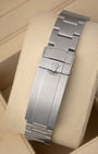 A rear view of the solid three-row metal watch band focusing on the completely brushed folding Oysterlock safety clasp with an integrated Glidelock micro-adjustment mechanism