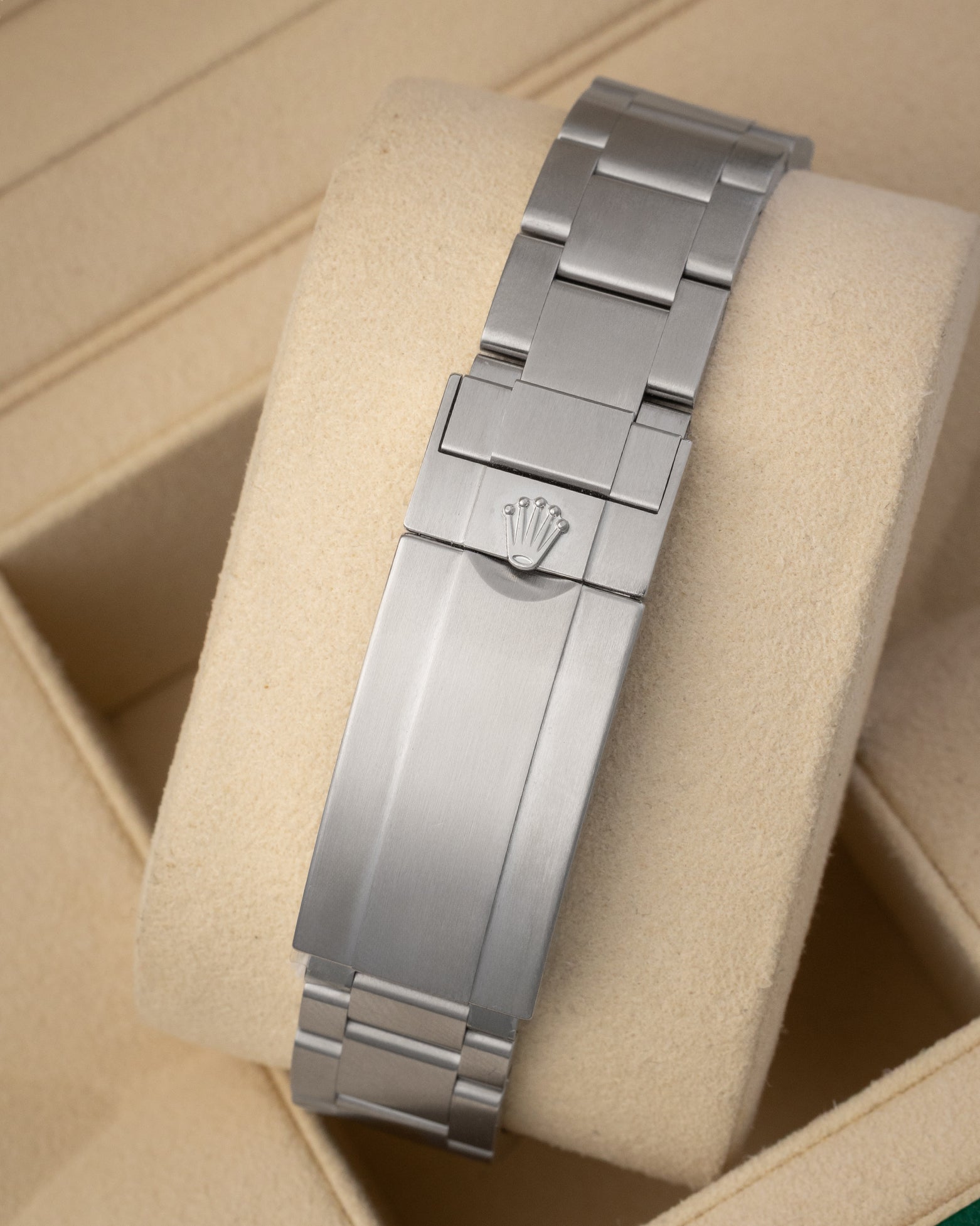 A rear view of the solid three-row metal watch band focusing on the completely brushed folding Oysterlock safety clasp with an integrated Glidelock micro-adjustment mechanism