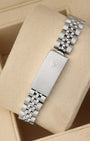 A rear view of the five-piece steel link metal watch band focusing on the secure closure of the classic stamped fold-over deployant clasp detailed with an embossed Rolex crown logo