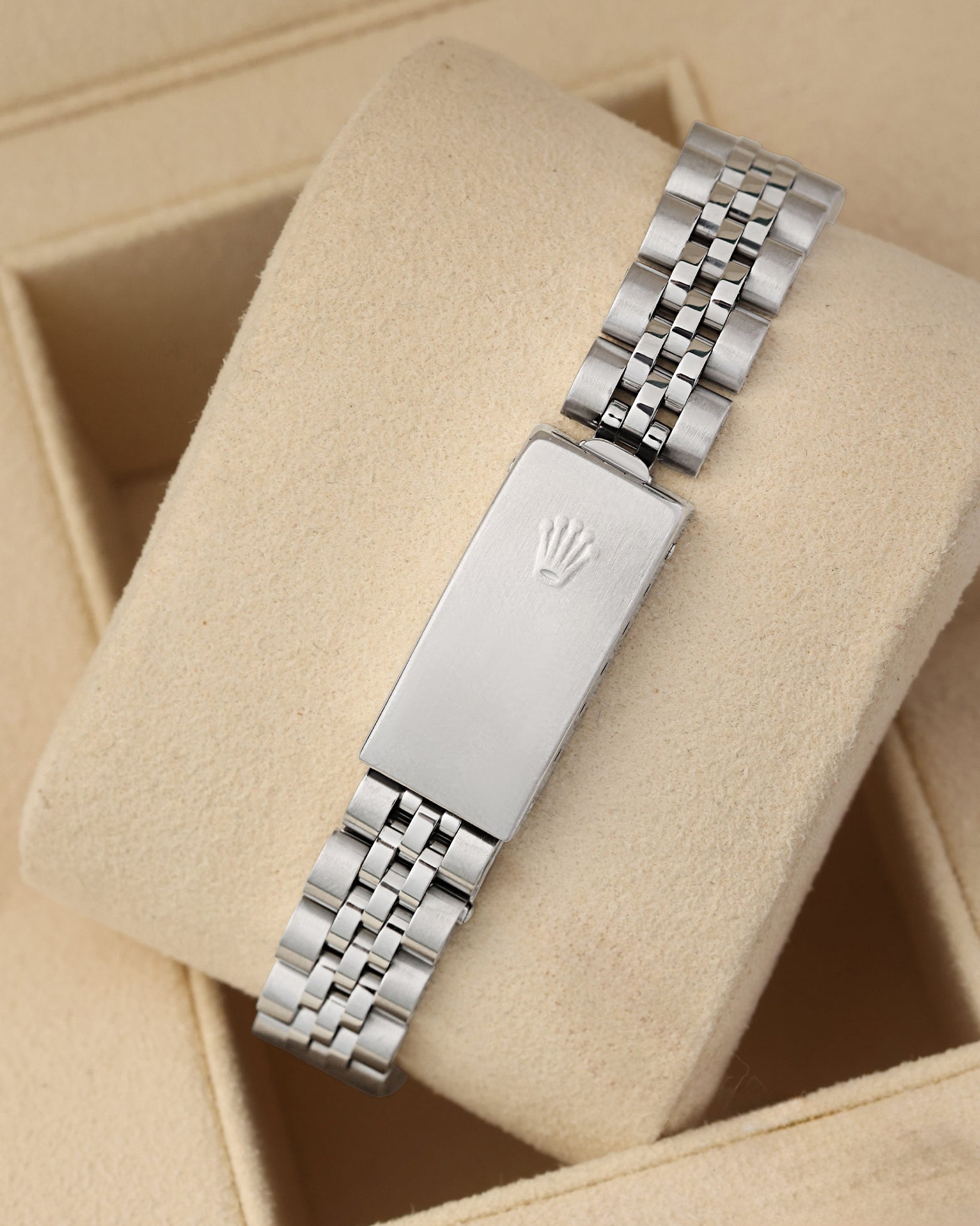A rear view of the five-piece steel link metal watch band focusing on the secure closure of the classic stamped fold-over deployant clasp detailed with an embossed Rolex crown logo